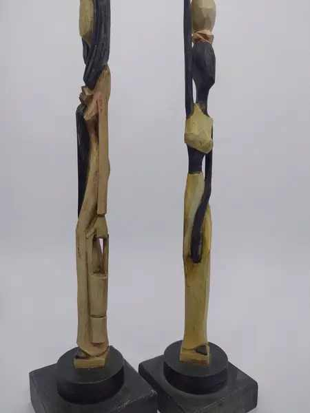 Foto de um(a) Par de esculturas africanas em madeira, da categoria de Escultura. Par de esculturas africanas em madeira, pintada à mão, retratando mulheres carregando baldes. Mede A: 31cm. Mostrado de uma perspectiva diferente. Vendido no marketplace Trésors.