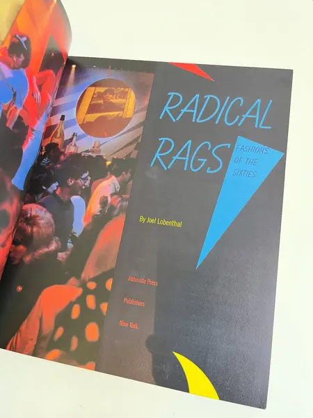 Foto de um(a) Livro Radical Rags - Fashions of the Sixties 1990, da categoria de Livros. Livro capa brochura de 1990, em inglês, sobre a moda da seca de 1960. Leves marcas do tempo. 256 páginas. Mostrado de uma perspectiva diferente. Vendido no marketplace Trésors.