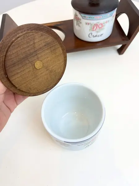 Foto de um(a) ​Porta temperos em porcelana Schmidt, da categoria de Garrafas, potes e jarros. Porta temperos em porcelana Schmidt estampada com tampa e suporte e madeira. Leves marcas do tempo e uso. Medidas totais:... Mostrado de uma perspectiva diferente. Vendido no marketplace Trésors.