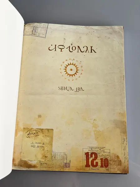 Foto de um(a) Livro de ilustrações decorativo em capa dura, da categoria de Livros. Livro capa dura, de 2021, em português, mas ele é somente com ilustrações. Conta história de imigrantes. Leves marcas do... Mostrado de uma perspectiva diferente. Vendido no marketplace Trésors.