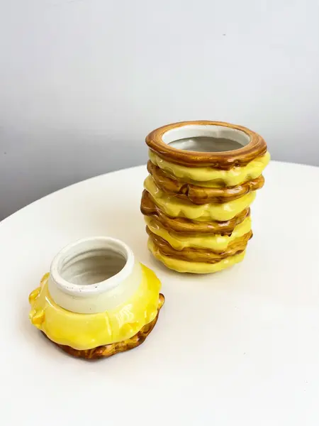 Foto de um(a) Pote em cerâmica formato panquecas, da categoria de Garrafas, potes e jarros. Pote com tampa da marca Bon Gourmet em cerâmica pintada a mão simulando pilha de panquecas com açúcar por cima. Possui um... Mostrado de uma perspectiva diferente. Vendido no marketplace Trésors.