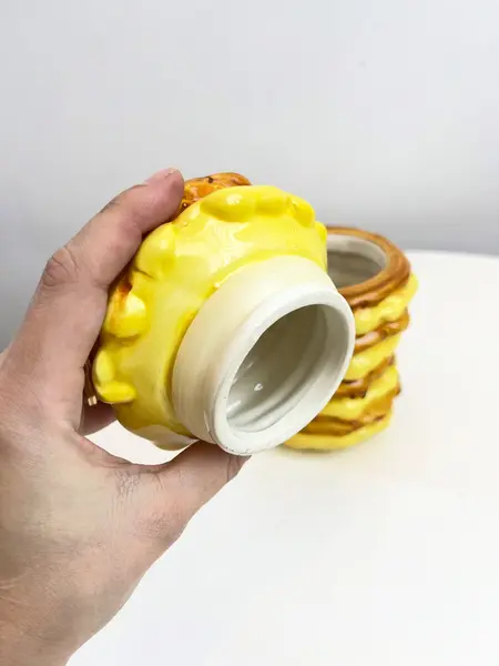Foto de um(a) Pote em cerâmica formato panquecas, da categoria de Garrafas, potes e jarros. Pote com tampa da marca Bon Gourmet em cerâmica pintada a mão simulando pilha de panquecas com açúcar por cima. Possui um... Mostrado de uma perspectiva diferente. Vendido no marketplace Trésors.