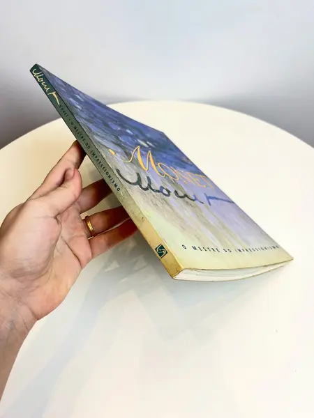 Foto de um(a) Livro decorativo Monet, da categoria de Livros. Livro capa brochura em português de 1997. Marcas do tempo e uso. 126 páginas. Mostrado de uma perspectiva diferente. Vendido no marketplace Trésors.