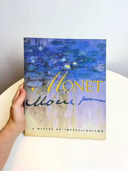 Foto de um(a) Livro decorativo Monet, da categoria de Livros. Livro capa brochura em português de 1997. Marcas do tempo e uso. 126 páginas. Mostrado de uma perspectiva diferente. Vendido no marketplace Trésors.
