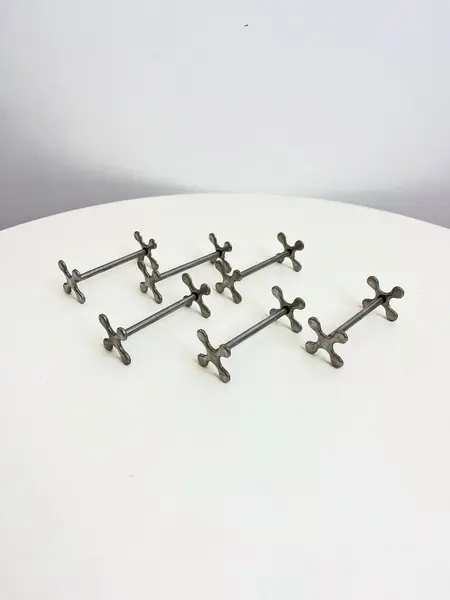 Foto de um(a) ​Jogo com 6 apoios de talher em metal, da categoria de Outros utensílios. Jogo com 6 apoios de talher em metal. Leves marcas do tempo e uso. Medidas: 7x3cm cada. Mostrado de uma perspectiva diferente. Vendido no marketplace Trésors.