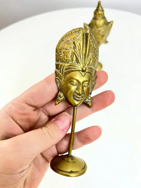 Foto de um(a) Dupla de máscaras orientais em bronze, da categoria de Escultura. Dupla de máscaras orientais em bronze. Leves marcas do tempo. Medidas maior: 13x6cm. Mostrado de uma perspectiva diferente. Vendido no marketplace Trésors.