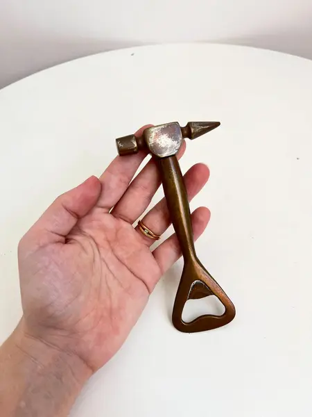 Foto de um(a) ​Abridor de garrafas em metal, da categoria de Abridores de garrafas. Abridor de garrafas em metal com desgastes no banho como nas fotos. Medidas: 14x7cm. Mostrado de uma perspectiva diferente. Vendido no marketplace Trésors.