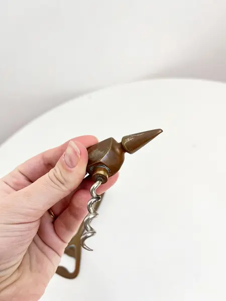 Foto de um(a) ​Abridor de garrafas em metal, da categoria de Abridores de garrafas. Abridor de garrafas em metal com desgastes no banho como nas fotos. Medidas: 14x7cm. Mostrado de uma perspectiva diferente. Vendido no marketplace Trésors.