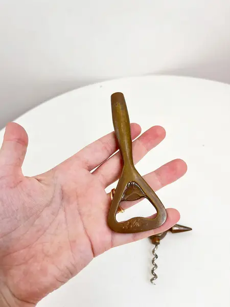 Foto de um(a) ​Abridor de garrafas em metal, da categoria de Abridores de garrafas. Abridor de garrafas em metal com desgastes no banho como nas fotos. Medidas: 14x7cm. Mostrado de uma perspectiva diferente. Vendido no marketplace Trésors.