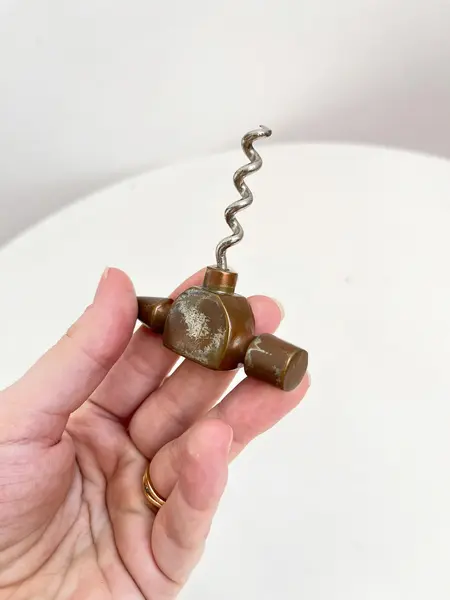 Foto de um(a) ​Abridor de garrafas em metal, da categoria de Abridores de garrafas. Abridor de garrafas em metal com desgastes no banho como nas fotos. Medidas: 14x7cm. Mostrado de uma perspectiva diferente. Vendido no marketplace Trésors.