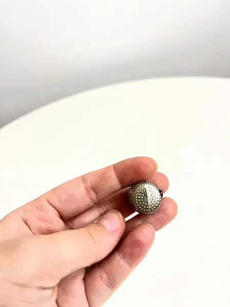 Foto de um(a) ​Dedal em metal com desenho de galo português, da categoria de Outros colecionáveis. Dedal em metal com desenho de galo português. Leves marcas do tempo e uso. Medidas: 3x2cm. Mostrado de uma perspectiva diferente. Vendido no marketplace Trésors.