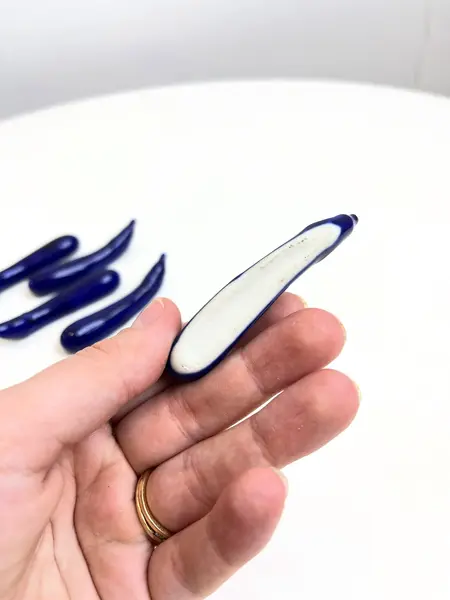 Foto de um(a) ​Jogo com 6 apoios de talheres em porcelana, da categoria de Outros utensílios. Jogo com 6 apoios de talheres em porcelana pintada em azul marinho no formado de berinjelas. Perfeito estado. Medidas:... Mostrado de uma perspectiva diferente. Vendido no marketplace Trésors.