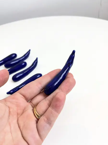 Foto de um(a) ​Jogo com 6 apoios de talheres em porcelana, da categoria de Outros utensílios. Jogo com 6 apoios de talheres em porcelana pintada em azul marinho no formado de berinjelas. Perfeito estado. Medidas:... Mostrado de uma perspectiva diferente. Vendido no marketplace Trésors.