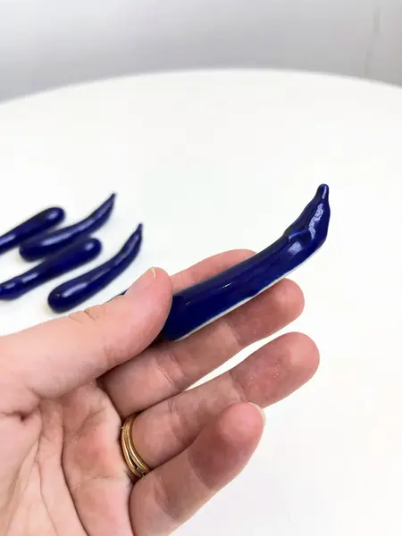 Foto de um(a) ​Jogo com 6 apoios de talheres em porcelana, da categoria de Outros utensílios. Jogo com 6 apoios de talheres em porcelana pintada em azul marinho no formado de berinjelas. Perfeito estado. Medidas:... Mostrado de uma perspectiva diferente. Vendido no marketplace Trésors.