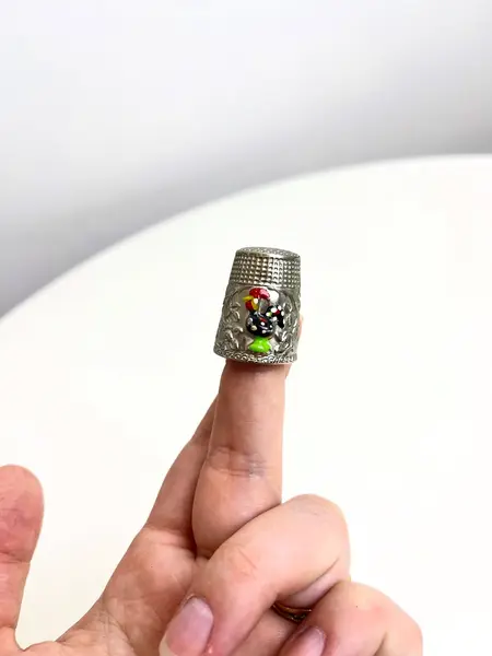 Foto de um(a) ​Dedal em metal com desenho de galo português, da categoria de Outros colecionáveis. Dedal em metal com desenho de galo português. Leves marcas do tempo e uso. Medidas: 3x2cm. Mostrado de uma perspectiva diferente. Vendido no marketplace Trésors.
