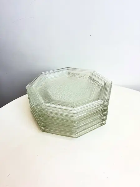 Foto de um(a) Jogo com 06 pratos de sobremesa, da categoria de Jogos de pratos. Jogo com 6 pratos de sobremesa em vidro texturizado, da década de 70. Perfeito estado. Medidas: 20x20cm. Mostrado de uma perspectiva diferente. Vendido no marketplace Trésors.