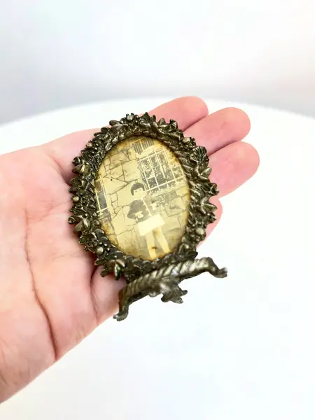 Foto de um(a) Pequeno porta retrato em metal, da categoria de Porta retratos. Pequeno porta retrato em metal. Marcas do tempo e uso como nas fotos. Medidas: 7x5cm. Mostrado de uma perspectiva diferente. Vendido no marketplace Trésors.