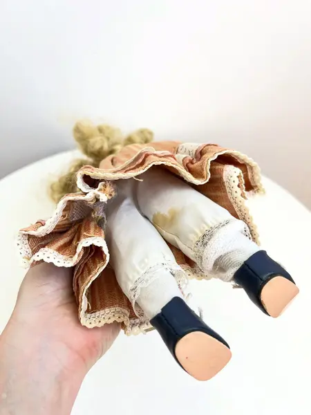 Foto de um(a) ​Boneca de porcelana, da categoria de Brinquedos e Hobbies. Boneca de porcelana com leves marcas do tempo e uso. Com suporte. Medidas: 30x16cm. Mostrado de uma perspectiva diferente. Vendido no marketplace Trésors.