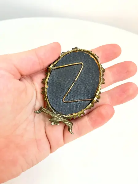 Foto de um(a) Pequeno porta retrato em metal, da categoria de Porta retratos. Pequeno porta retrato em metal. Marcas do tempo e uso como nas fotos. Medidas: 7x5cm. Mostrado de uma perspectiva diferente. Vendido no marketplace Trésors.