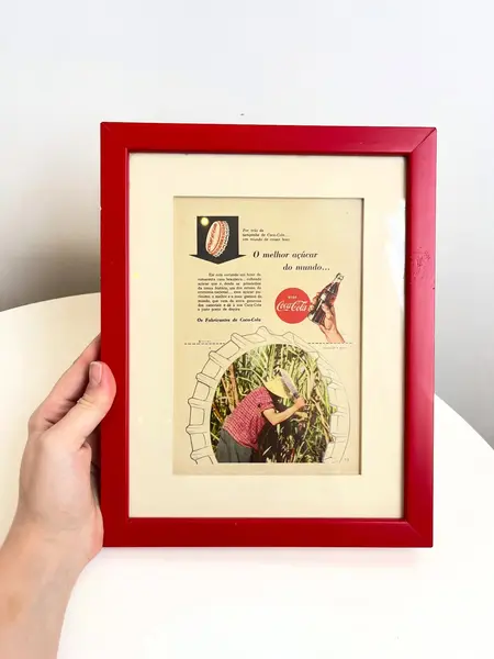 Foto de um(a) Quadro ​de propaganda da Coca Cola - 1954, da categoria de Propagandas. Propaganda da coca cola, de 1954, emoldurada com vidro. Moldura tem algumas avarias como nas fotos. Medidas: 27x21cm. Mostrado de uma perspectiva diferente. Vendido no marketplace Trésors.
