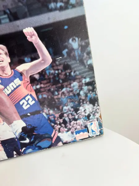Foto de um(a) ​Pôster de basquete - Charles Barkley 1993 Phoenix Suns, da categoria de Cartazes. Pôster colado na madeira, de 1993. Possui marcas do tempo e uso como nas fotos. Medidas: 50x41cm. Mostrado de uma perspectiva diferente. Vendido no marketplace Trésors.