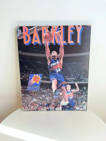 Foto de um(a) ​Pôster de basquete - Charles Barkley 1993 Phoenix Suns, da categoria de Cartazes. Pôster colado na madeira, de 1993. Possui marcas do tempo e uso como nas fotos. Medidas: 50x41cm. Mostrado de uma perspectiva diferente. Vendido no marketplace Trésors.