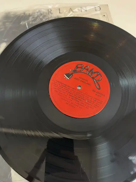 Foto de um(a) ​LP de 1979 Judy Garland, da categoria de LPs ou Discos de Vinil . LP de 1979, Judy Garland. Capa com leves avarias e disco em perfeito estado. Mostrado de uma perspectiva diferente. Vendido no marketplace Trésors.