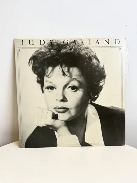 Foto de um(a) ​LP de 1979 Judy Garland, da categoria de LPs ou Discos de Vinil . LP de 1979, Judy Garland. Capa com leves avarias e disco em perfeito estado. Mostrado de uma perspectiva diferente. Vendido no marketplace Trésors.