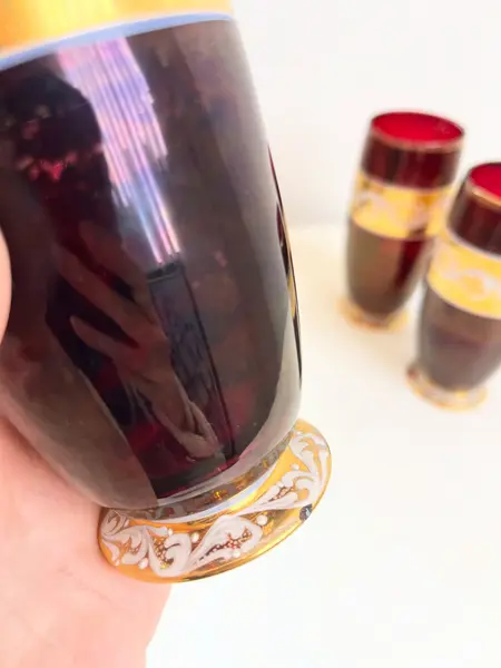 Foto de um(a) ​Trio de copos altos de vidro da década de 50, da categoria de Copos. Trio de copos altos de vidro da década de 50, pintados em bordô, dourado e branco. Marcas do tempo e uso e um com mínimo... Mostrado de uma perspectiva diferente. Vendido no marketplace Trésors.