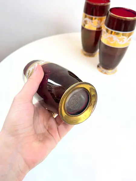 Foto de um(a) ​Trio de copos altos de vidro da década de 50, da categoria de Copos. Trio de copos altos de vidro da década de 50, pintados em bordô, dourado e branco. Marcas do tempo e uso e um com mínimo... Mostrado de uma perspectiva diferente. Vendido no marketplace Trésors.