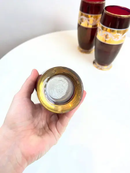 Foto de um(a) ​Trio de copos altos de vidro da década de 50, da categoria de Copos. Trio de copos altos de vidro da década de 50, pintados em bordô, dourado e branco. Marcas do tempo e uso e um com mínimo... Mostrado de uma perspectiva diferente. Vendido no marketplace Trésors.