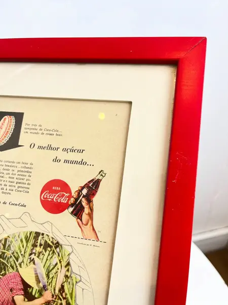 Foto de um(a) Quadro ​de propaganda da Coca Cola - 1954, da categoria de Propagandas. Propaganda da coca cola, de 1954, emoldurada com vidro. Moldura tem algumas avarias como nas fotos. Medidas: 27x21cm. Mostrado de uma perspectiva diferente. Vendido no marketplace Trésors.