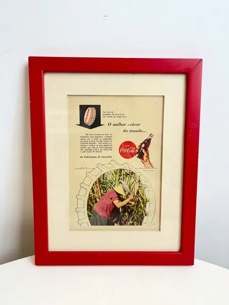 Foto de um(a) Quadro ​de propaganda da Coca Cola - 1954, da categoria de Propagandas. Propaganda da coca cola, de 1954, emoldurada com vidro. Moldura tem algumas avarias como nas fotos. Medidas: 27x21cm. Mostrado de uma perspectiva diferente. Vendido no marketplace Trésors.