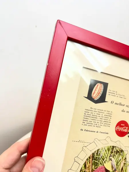 Foto de um(a) Quadro ​de propaganda da Coca Cola - 1954, da categoria de Propagandas. Propaganda da coca cola, de 1954, emoldurada com vidro. Moldura tem algumas avarias como nas fotos. Medidas: 27x21cm. Mostrado de uma perspectiva diferente. Vendido no marketplace Trésors.