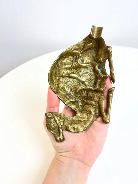 Foto de um(a) Cinzeiro em bronze cinzelado formato camelo, da categoria de Cinzeiros. Cinzeiro em bronze cinzelado. Marcas do tempo e uso como nas fotos. Medidas: 17x10cm. Mostrado de uma perspectiva diferente. Vendido no marketplace Trésors.