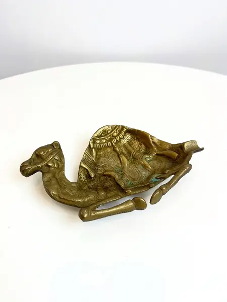 Foto de um(a) Cinzeiro em bronze cinzelado formato camelo, da categoria de Cinzeiros. Cinzeiro em bronze cinzelado. Marcas do tempo e uso como nas fotos. Medidas: 17x10cm. Mostrado de uma perspectiva diferente. Vendido no marketplace Trésors.