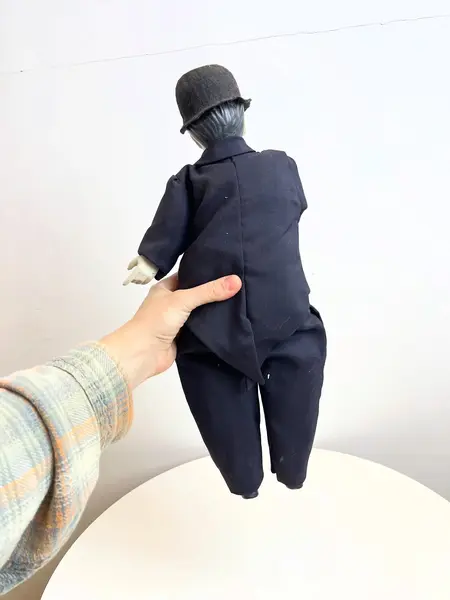 Foto de um(a) ​Boneco Charles Chaplin em porcelana e tecido, da categoria de Bonecos de arte. Boneco do Charles Chaplin em porcelana e tecido, com bengala em metal e chapéu em feltro. Marcas do tempo e uso mas sem nada... Mostrado de uma perspectiva diferente. Vendido no marketplace Trésors.