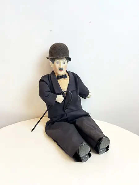 Foto de um(a) ​Boneco Charles Chaplin em porcelana e tecido, da categoria de Bonecos de arte. Boneco do Charles Chaplin em porcelana e tecido, com bengala em metal e chapéu em feltro. Marcas do tempo e uso mas sem nada... Mostrado de uma perspectiva diferente. Vendido no marketplace Trésors.