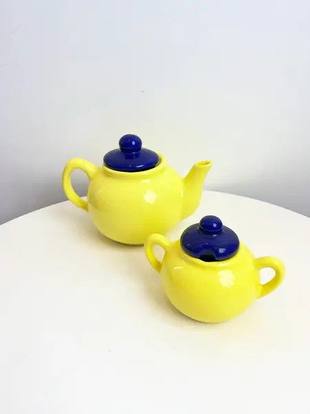 Foto de um(a) Bule e açucareiro em cerâmica, da categoria de Açucareiro. Jogo em cerâmica com bule e açucareiro. Leves marcas do tempo como os fios de cabelo. Medidas bule: 20x13cm. Medidas... Mostrado de uma perspectiva diferente. Vendido no marketplace Trésors.