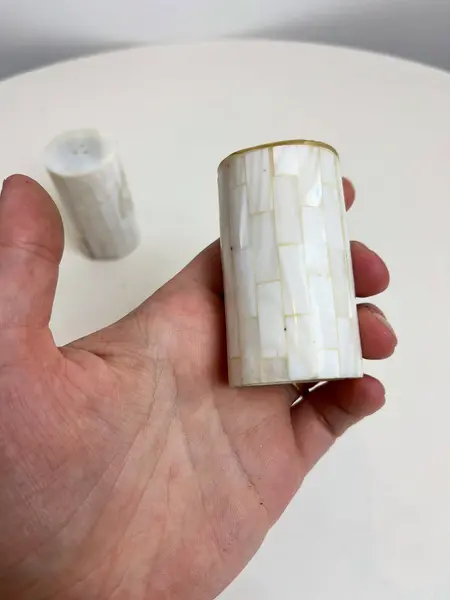 Foto de um(a) Saleiro e pimenteiro revestido em madrepérola, da categoria de Saleiros e pimenteiros. Dupla de saleiro e pimenteiro revestido em madrepérola. Leves marcas do tempo e uso. Medidas: 6x3cm cada. Mostrado de uma perspectiva diferente. Vendido no marketplace Trésors.