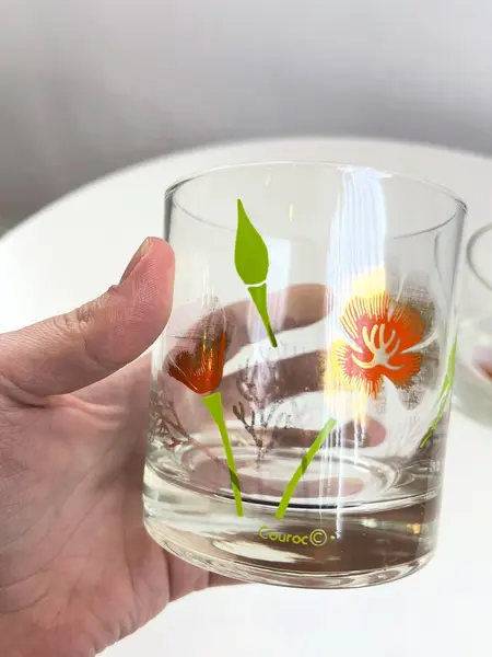 Foto de um(a) Conjunto com 04 copos em vidro estampado - Couroc, da categoria de Copos. Conjunto com 04 copos em vidro estampado da marca Couroc. Leve desgaste na estampa. Medidas: 9x8cm. Mostrado de uma perspectiva diferente. Vendido no marketplace Trésors.