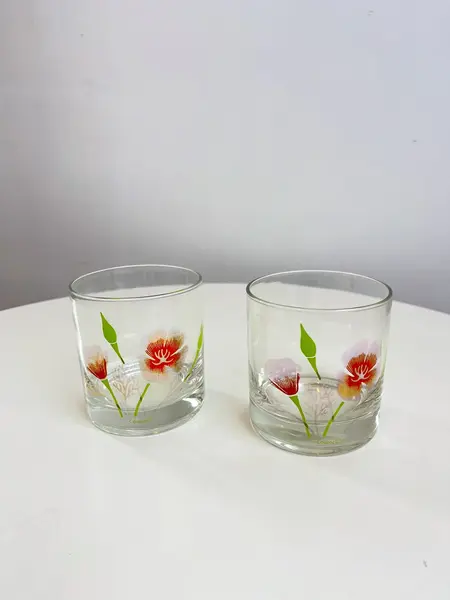 Foto de um(a) Conjunto com 04 copos em vidro estampado - Couroc, da categoria de Copos. Conjunto com 04 copos em vidro estampado da marca Couroc. Leve desgaste na estampa. Medidas: 9x8cm. Mostrado de uma perspectiva diferente. Vendido no marketplace Trésors.