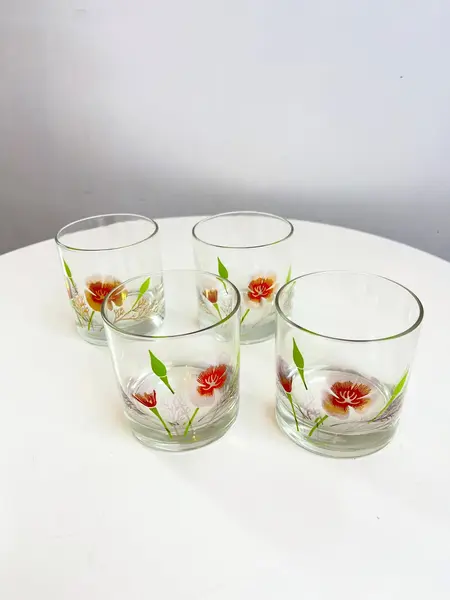 Foto de um(a) Conjunto com 04 copos em vidro estampado - Couroc, da categoria de Copos. Conjunto com 04 copos em vidro estampado da marca Couroc. Leve desgaste na estampa. Medidas: 9x8cm. Mostrado de uma perspectiva diferente. Vendido no marketplace Trésors.