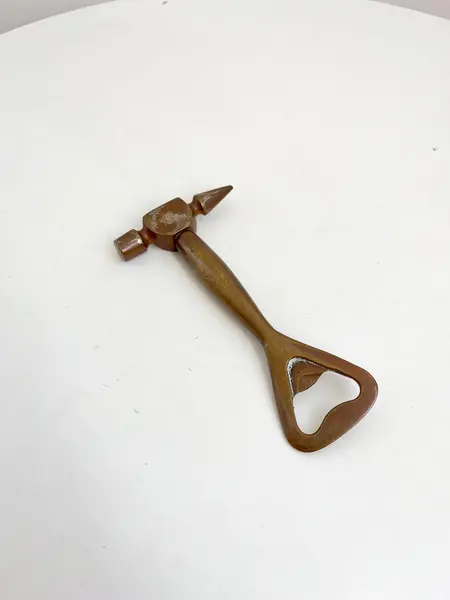 Foto de um(a) ​Abridor de garrafas em metal, da categoria de Abridores de garrafas. Abridor de garrafas em metal com desgastes no banho como nas fotos. Medidas: 14x7cm. Mostrado de uma perspectiva diferente. Vendido no marketplace Trésors.