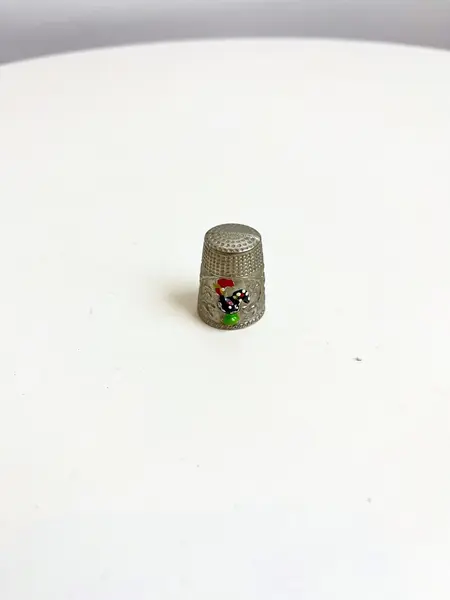 Foto de um(a) ​Dedal em metal com desenho de galo português, da categoria de Outros colecionáveis. Dedal em metal com desenho de galo português. Leves marcas do tempo e uso. Medidas: 3x2cm. Mostrado de uma perspectiva diferente. Vendido no marketplace Trésors.