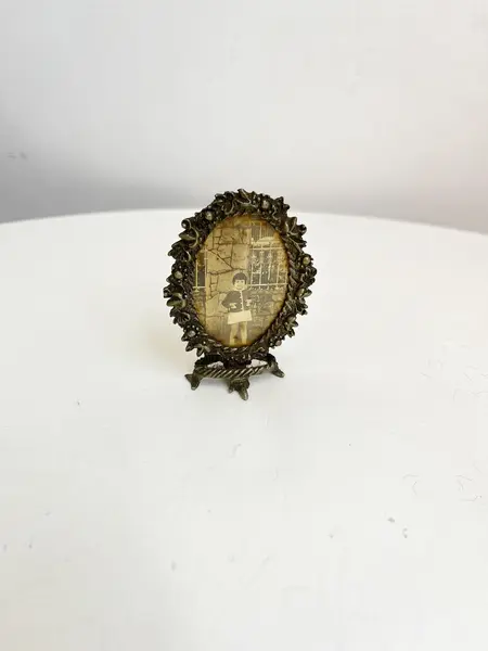 Foto de um(a) Pequeno porta retrato em metal, da categoria de Porta retratos. Pequeno porta retrato em metal. Marcas do tempo e uso como nas fotos. Medidas: 7x5cm. Mostrado de uma perspectiva diferente. Vendido no marketplace Trésors.