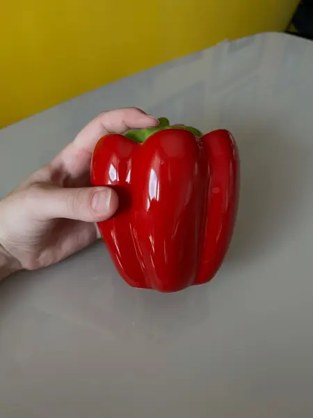 Foto de um(a) ​Pote com tampa em cerâmica formato pimentão, da categoria de Garrafas, potes e jarros. Pote com tampa em cerâmica. Possui lascado interno na tampa como mostrado nas fotos. Medidas: 12x10cm. Mostrado de uma perspectiva diferente. Vendido no marketplace Trésors.