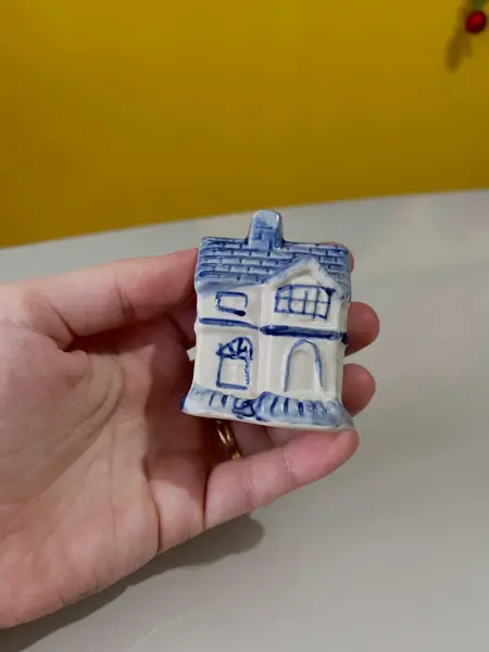 Foto de um(a) ​Enfeite casinha azul e branca em porcelana, da categoria de Objetos decorativos. Casinha em porcelana. Perfeito estado. Medidas: 5x4x6cm. Mostrado de uma perspectiva diferente. Vendido no marketplace Trésors.