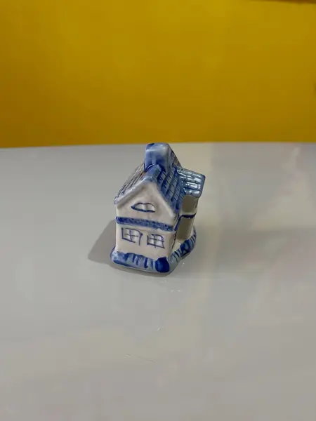Foto de um(a) ​Enfeite casinha azul e branca em porcelana, da categoria de Objetos decorativos. Casinha em porcelana. Perfeito estado. Medidas: 5x4x6cm. Mostrado de uma perspectiva diferente. Vendido no marketplace Trésors.