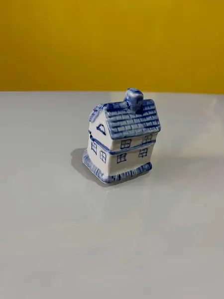 Foto de um(a) ​Enfeite casinha azul e branca em porcelana, da categoria de Objetos decorativos. Casinha em porcelana. Perfeito estado. Medidas: 5x4x6cm. Mostrado de uma perspectiva diferente. Vendido no marketplace Trésors.